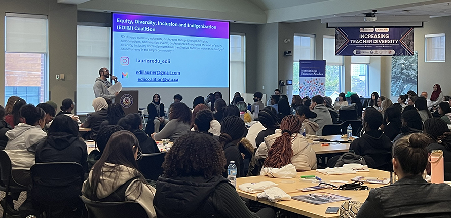 Increasing Teaching Diversity event in a large conference room with many participants sitting around tables watching a presenter