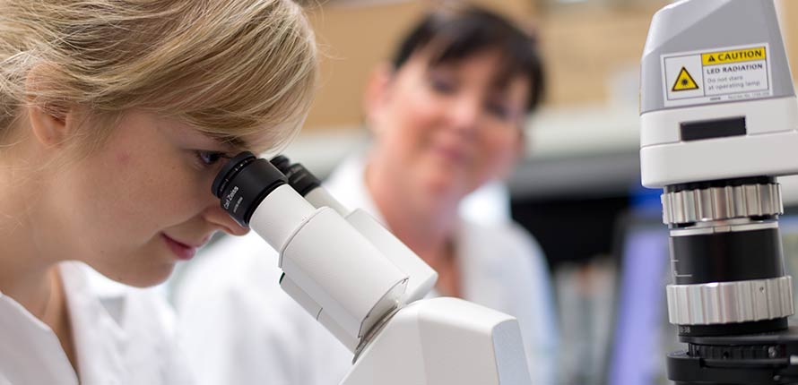 student looking into microscrope