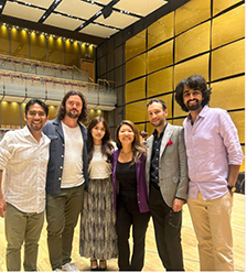 Kira Omelchenko posing with opera singers on stage