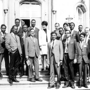 A black and white photo of a group of people standing on stairs. 