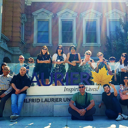 SOU Tour group posing around the Laurier sign