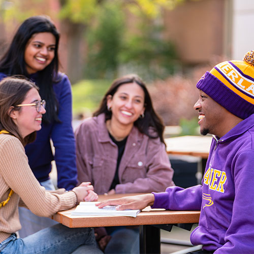 Three female students and one male student studying outside