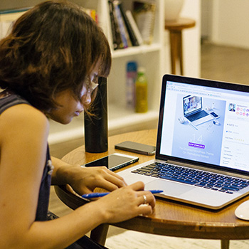 Woman working on a laptop at her kitchen table