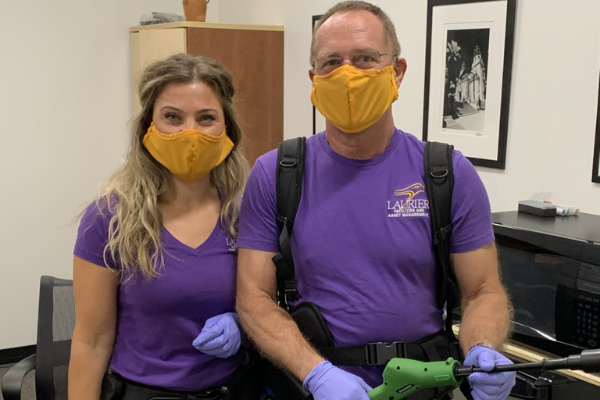 Two custodians wearing gold masks