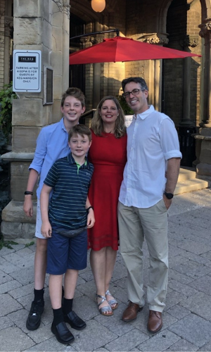 Man and woman standing with two boys.