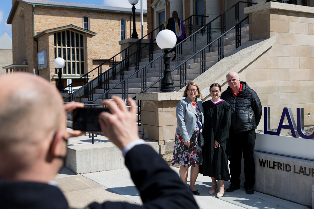 family takes photos in front of Laurier sign