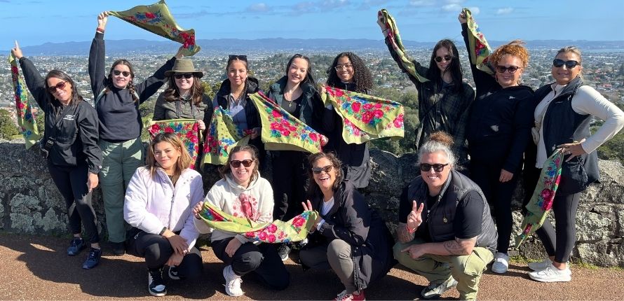 A group of women holding floral scarves